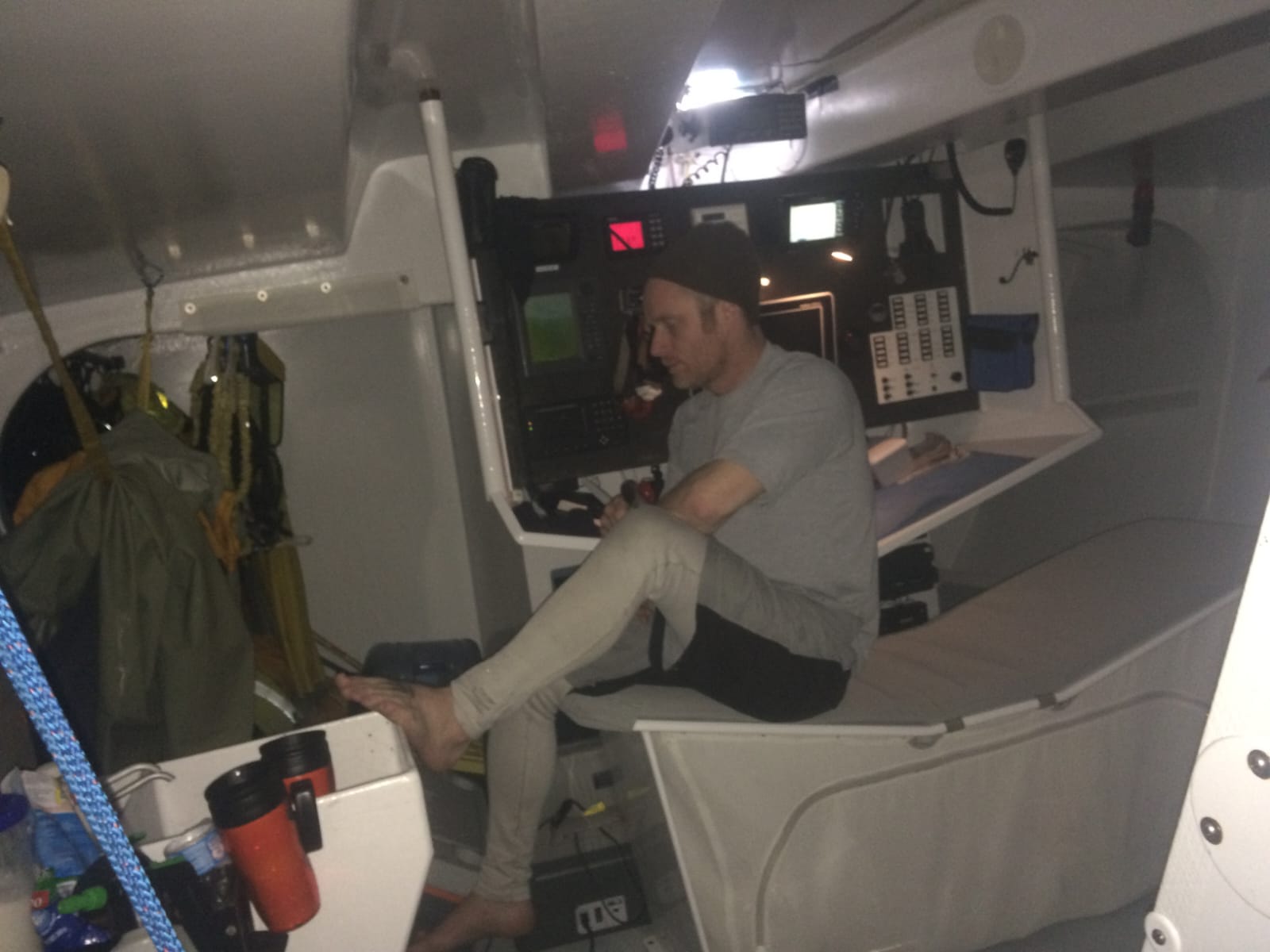 Chris Stanmore-Major at the navigation station below deck during the storm, instruments glowing