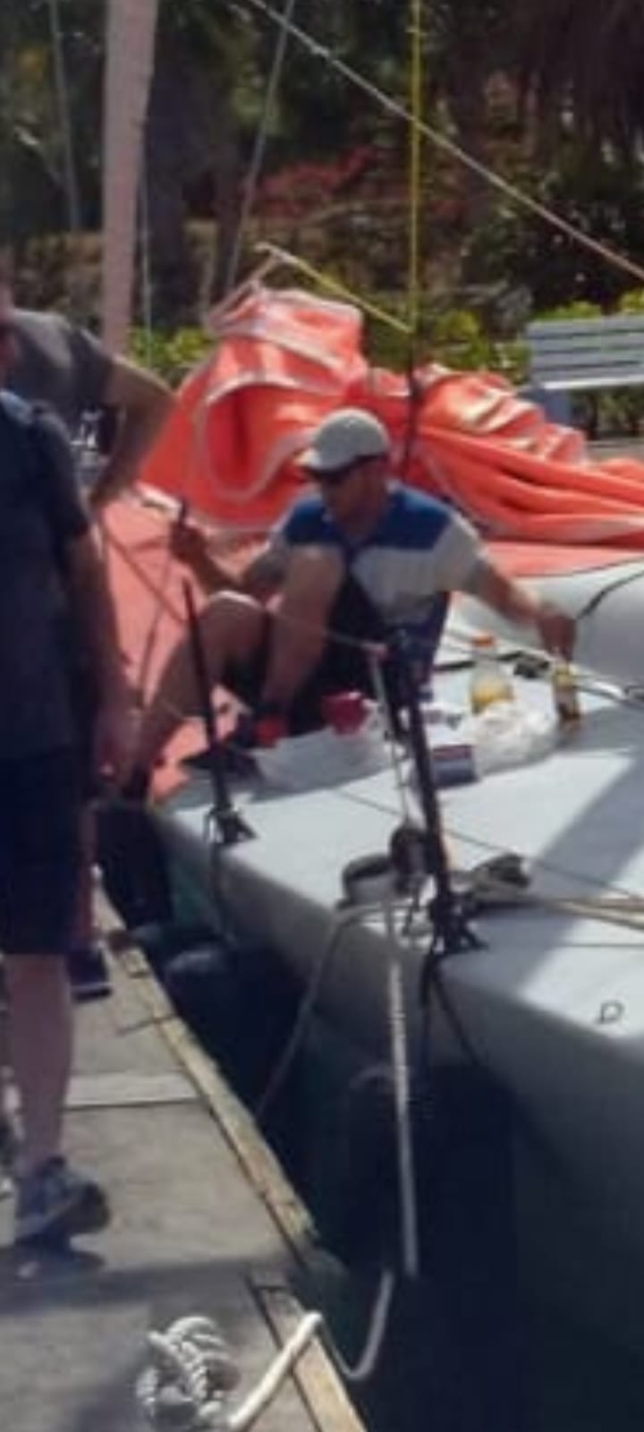 Ken zoomed in on the deck of Challenger in Antigua with a Corona and sandwich, working among red sail bags