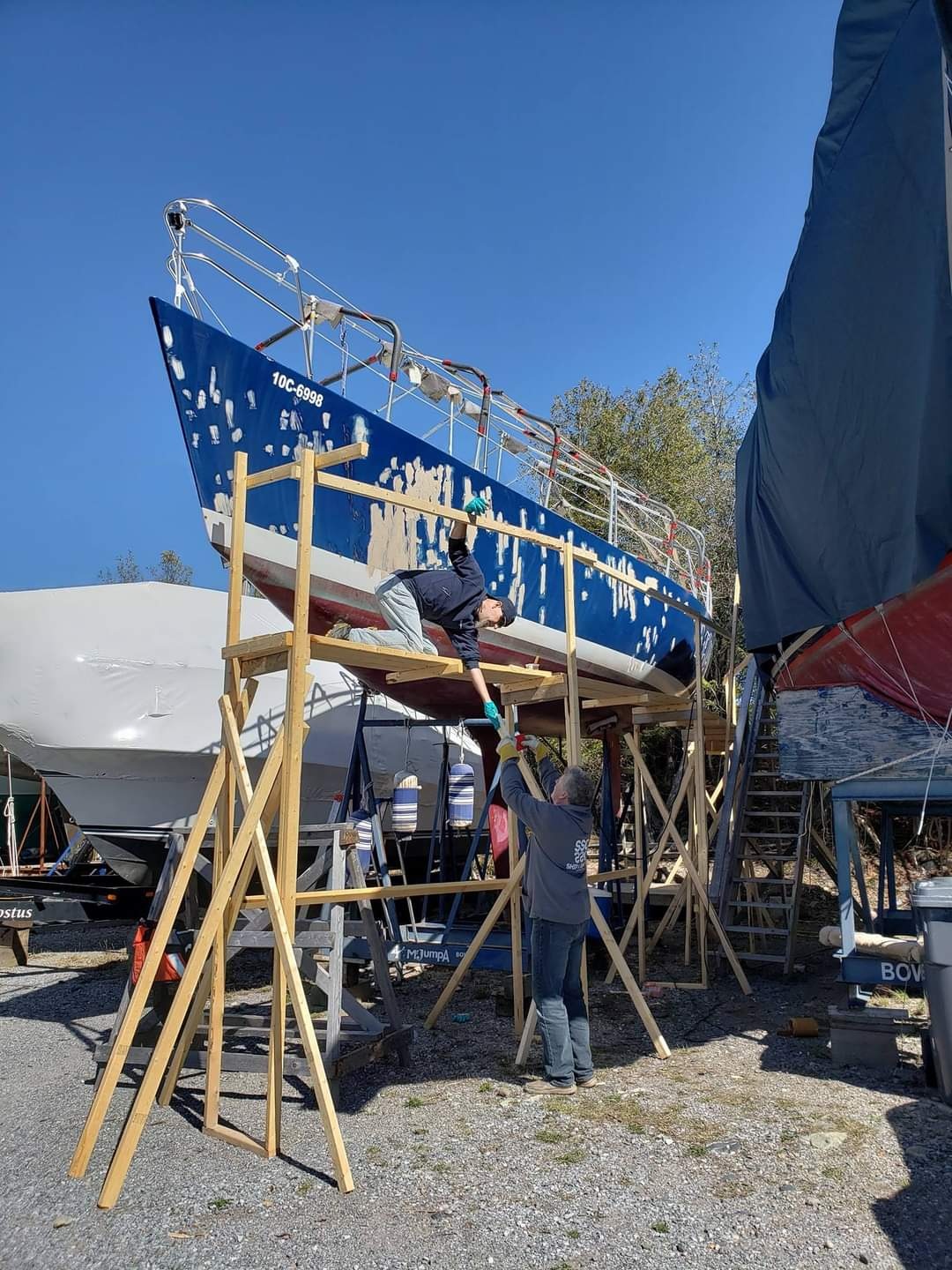 Mr Jumpa hauled out on scaffolding, hull being sanded and prepped for new paint