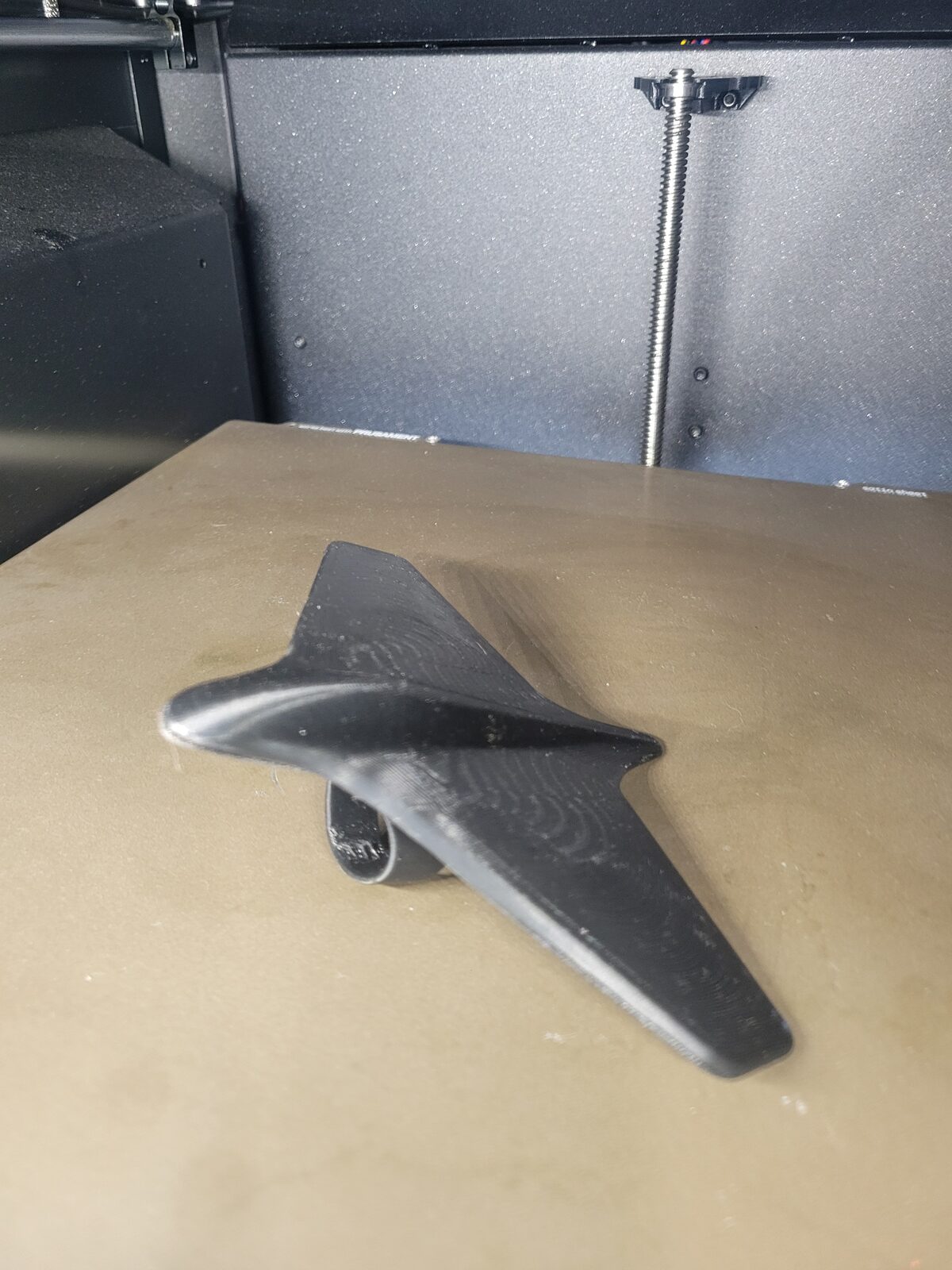 A black 3D-printed finger plane shaped like an aircraft